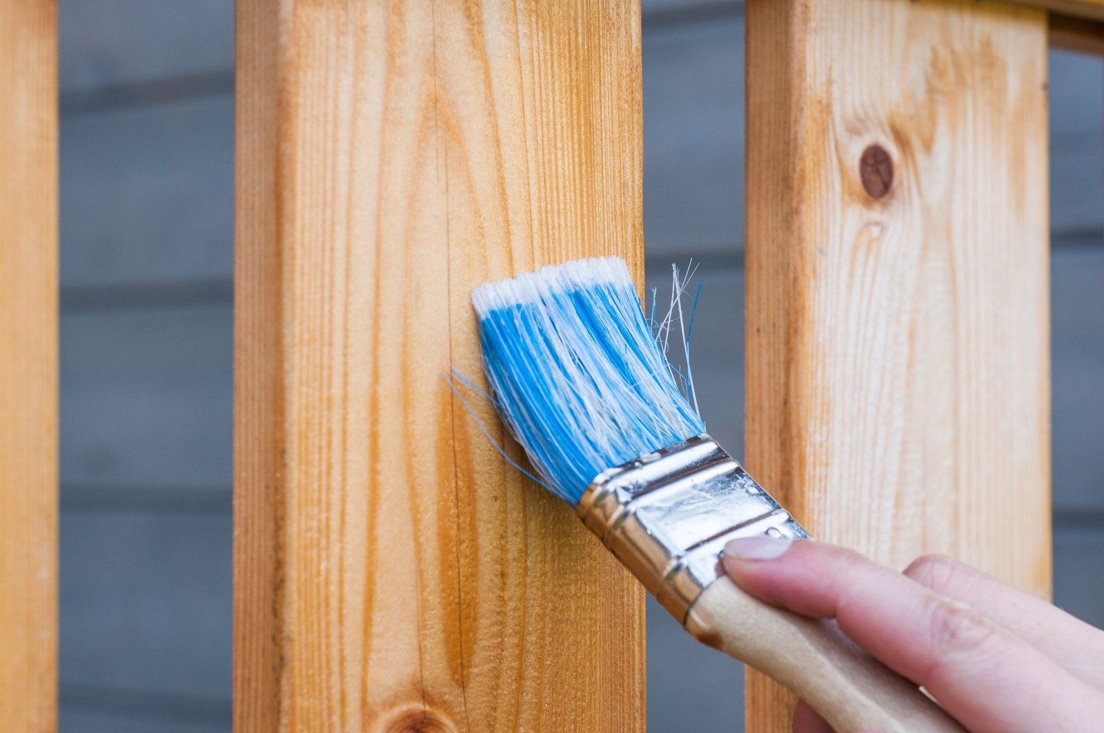 Brushing a protective waterproof sealer onto wood boards - Homex Builders